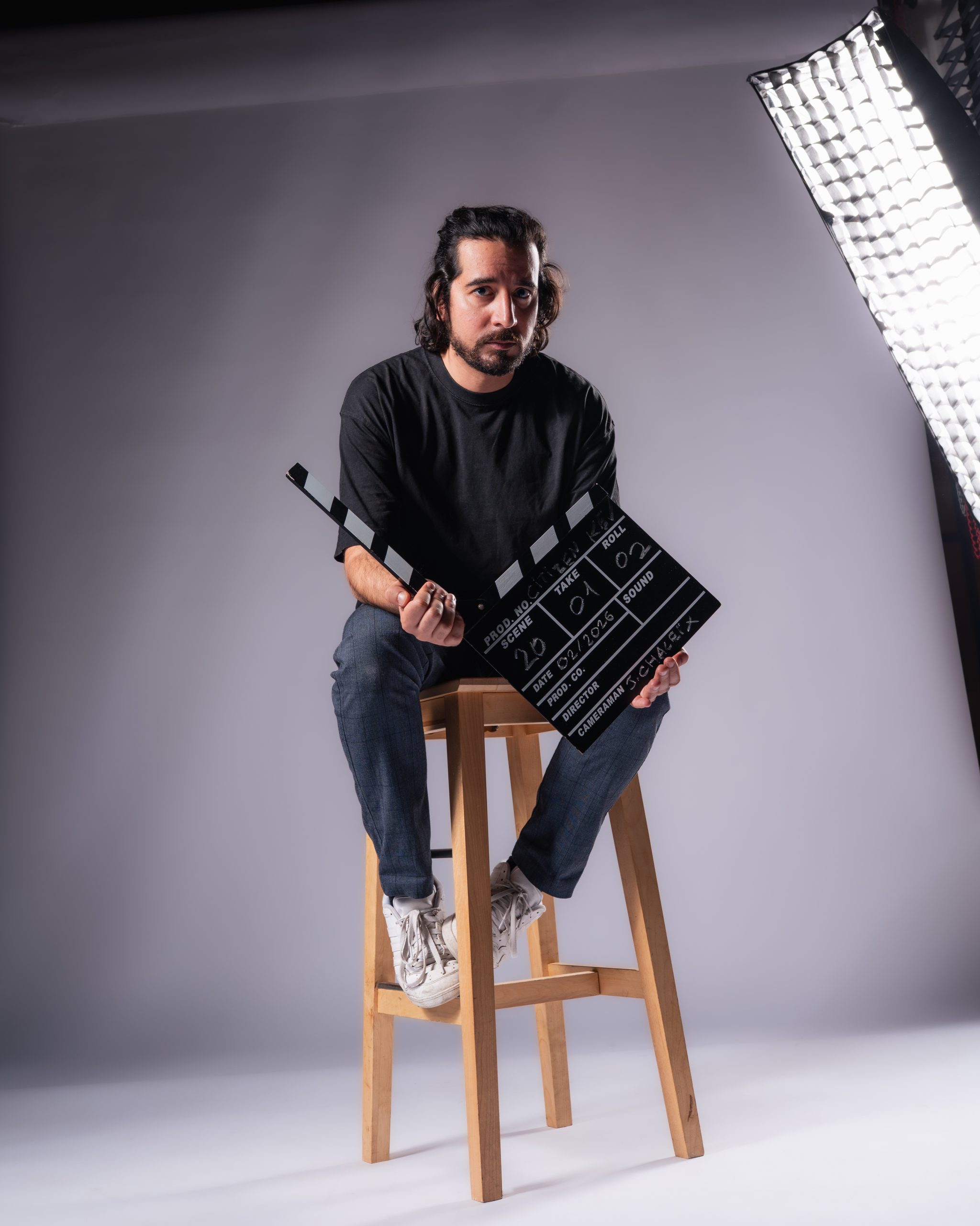 Portrait en grand angle d'un homme assis au milieu d'un studio photo à Bordeaux.